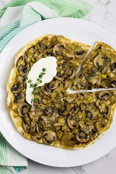 a mushroom and cheese pizza on a white plate