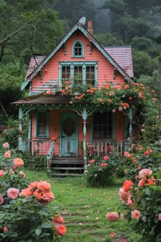 a pink house surrounded by flowers and greenery