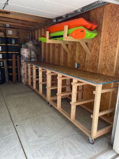 the inside of a garage with shelves and surfboards