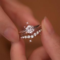 a person holding a diamond ring in their hand