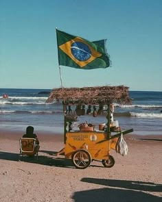 a small cart on the beach with a flag flying in the background