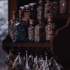 an old wooden shelf filled with lots of different types of spices and spice bottles next to each other