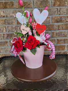 a pink flower pot with red roses and hearts