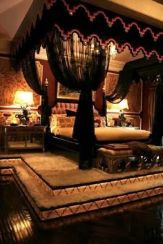 a bedroom with a canopy bed and chandelier on the ceiling is lit up