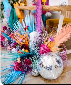 a disco ball and some colorful flowers on a table