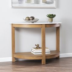 a white table with some books and a vase on it next to a framed photograph