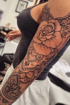 a woman's arm with a rose tattoo on the left side of her arm