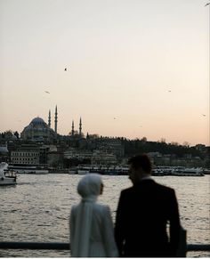 two people are looking out over the water