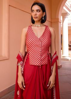 Elevate your wardrobe with this exquisite Red Embroidered Skirt Set, crafted from luxurious chanderi jacquard. The vibrant red blouse, adorned with intricate embroidery, exudes sophistication and style, making it perfect for festive occasions and special gatherings. Paired with a flowing skirt that drapes elegantly, this ensemble creates a flattering silhouette, blending traditional craftsmanship with contemporary design for a look that is both timeless and captivating. Style it with a layered c Red Designer Wear Sets With Traditional Drape, Red Traditional Drape Sets For Designer Wear, Embroidered Cotton Silk Pre-draped Saree For Party, Elegant Red Raw Silk Pre-draped Saree, Festive Brocade Pre-draped Saree For Diwali, Elegant Red Pre-draped Saree For Festive Occasions, Fitted Red Pre-draped Saree For Eid, Red Silk Fitted Pre-draped Saree, Red Cotton Silk Pre-draped Saree For Designer Wear