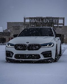 a white car is parked in the snow