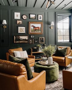 a living room with leather furniture and pictures on the wall above it's windows