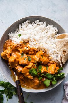 a plate with rice, chicken and cilantro on it next to a tortilla