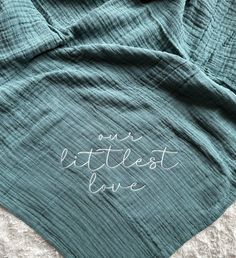 a blue blanket with the words our littlest love written on it