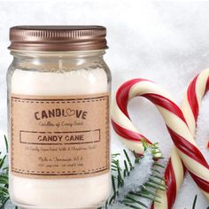 a jar filled with candy canes sitting on top of snow next to christmas decorations