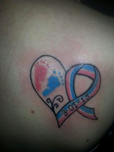 a heart shaped tattoo with a ribbon on it