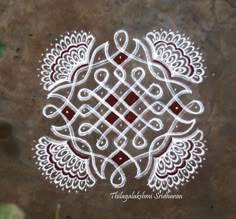 an intricate design on the ground with red and white dots in it's center