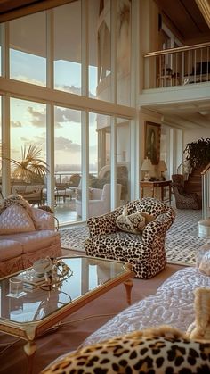 a living room filled with lots of furniture next to a large glass wall window overlooking the ocean