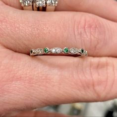 a woman's hand with two rings on it and three diamonds in the middle