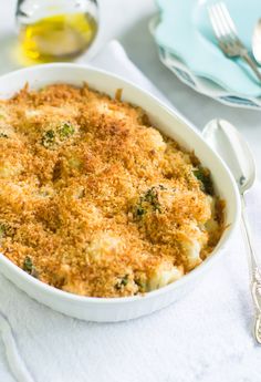 a casserole dish with cheese and broccoli in it on a table