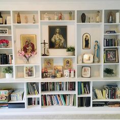 a white book shelf filled with lots of books and figurines on top of it