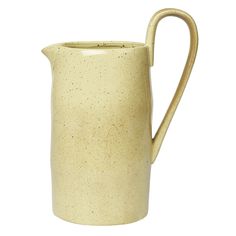 a cream colored pitcher with speckles on the outside and handle is shown against a white background