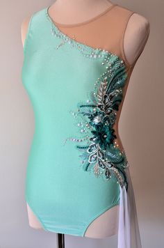 a woman's green leotard with blue and silver beading on it