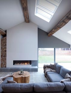 a living room with a couch, coffee table and fire place in the middle of it