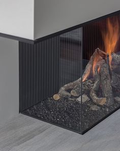 a fire is burning inside of a glass fireplace