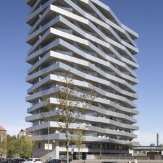 a very tall building sitting on the side of a road next to a parking lot