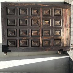 an old wooden window with metal rivets on it