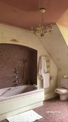 a bathroom with a chandelier, toilet and bathtub in the middle of it