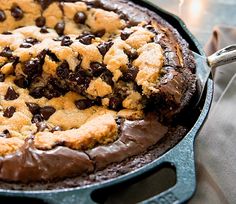 a chocolate chip cookie pie in a cast iron skillet with a serving utensil