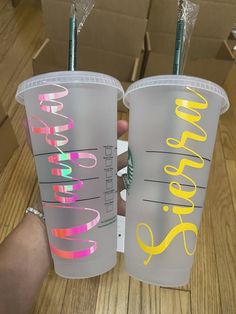 two plastic cups with straws in each one