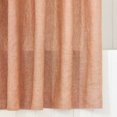 an orange curtain hanging on the side of a window