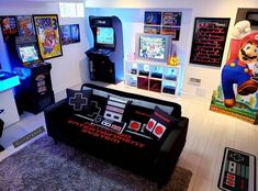 a living room filled with furniture and video game machines in it's center area