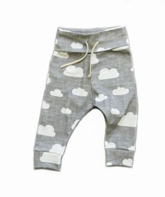 a small child's pants with clouds on the front and bottom, in grey