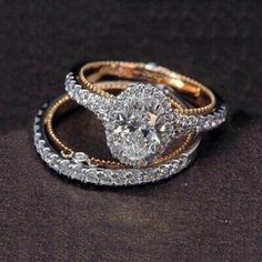 two wedding rings on top of each other with diamonds in the middle and gold bands around them