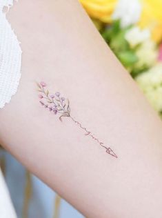 a woman's arm with a flower tattoo on the left side of her body