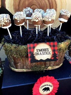 there are some marshmallows on sticks in a basket with grass and flowers