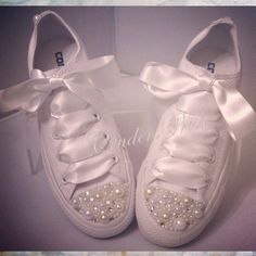 a pair of white shoes with bows and pearls