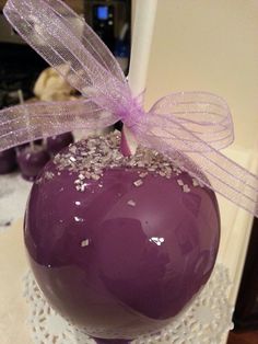 there is a purple cake ball on top of a doily with a pink bow