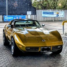 a gold colored car is parked on the street