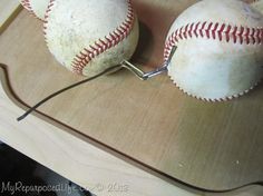 two baseballs sitting on top of a table with wires in the middle of them