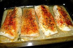 four fish fillets in a baking pan ready to be baked into the oven for dinner