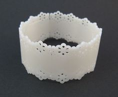 a close up of a white bracelet on a black surface