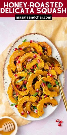 honey roasted delicata squash with pomegranates on a white plate