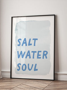 a framed poster with the words salt water soul on it in blue ink against a white wall