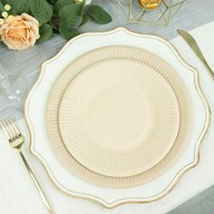 an empty plate on a table with silverware and flowers