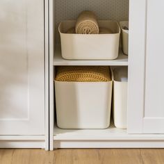 two white containers are sitting on top of each other in front of some cupboard doors