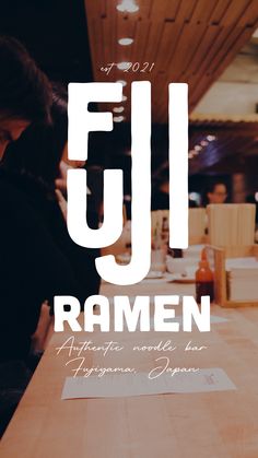 a person sitting at a table in front of a sign that reads,'fjl